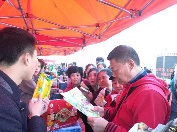 海伦市某食品企业销售人员在摊位前向市民介绍鲜食玉米口感和保健情况